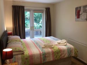 Four-Bedroom House - Stratherrick Free Parking في إينفيرنيس: غرفة نوم عليها سرير وفوط