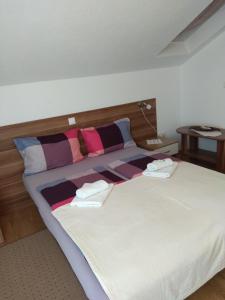 a bedroom with a large bed with two pillows at Apartments Matijevic in Grabovac