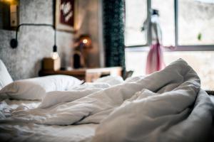 a bed with white sheets and pillows in a bedroom at Kook Hotel Tarifa in Tarifa