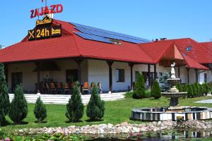 CzarnocinにあるZajazd Bachusの赤い屋根と噴水のあるリゾートビル