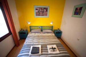 Dormitorio pequeño con cama con pared amarilla en GINGER apartment, en Alicante