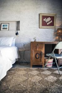 a bedroom with a bed and a table and a chair at Kook Hotel Tarifa in Tarifa