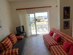 a living room with two couches and a balcony at Apartmani Marija in Primošten