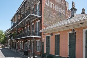a brick building with a fire escape on a street at French Quarter Mansion in New Orleans