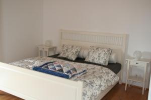um quarto com uma cama branca com duas mesas de cabeceira em Casa da Pedra-Quinta do Briando em Portalegre