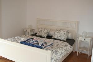 ein Schlafzimmer mit einem weißen Bett und zwei Nachttischen in der Unterkunft Casa da Pedra-Quinta do Briando in Portalegre