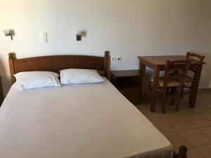 a bedroom with a bed and a table and a chair at Eugenia travasarou sea view appartments in Diakofti