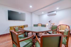 a conference room with a table and chairs and a flat screen tv at Hotel Campestre Nala in Palmira