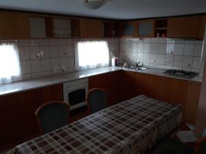 una pequeña cocina con mesa y fregadero en Rózsa apartman, en Lenti