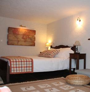 a bedroom with a white bed with a wooden headboard at Guesthouse Karahalios in Polydrossos