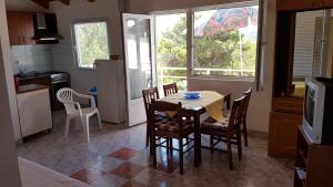 a kitchen with a table and chairs in a kitchen at Cozy apartment in Jezera
