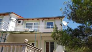 a white house with a balcony on top of it at Cozy apartment in Jezera