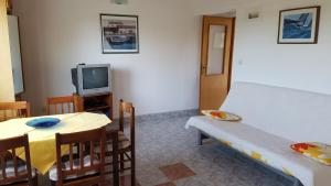 a room with a table and a bed and a tv at Cozy apartment in Jezera