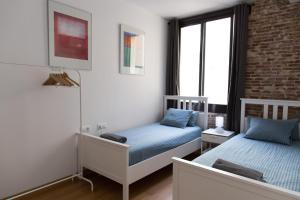Un dormitorio con dos camas y una pared de ladrillo. en Central Apartment, en Barcelona 10 fotos más
