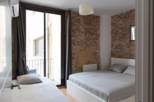 Un dormitorio con una cama y una pared de ladrillo. en Central Apartment, en Barcelona