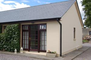 a small white house with a black roof at Inisfail in Killarney