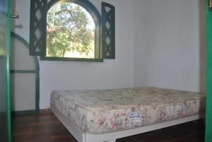 a bed in a room with a window at Radicais Natureza in Monte Alegre do Sul