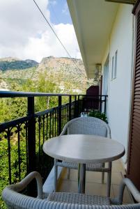 d'une table et de chaises sur un balcon avec vue. dans l'établissement Oasis Studios, à Paleóchora