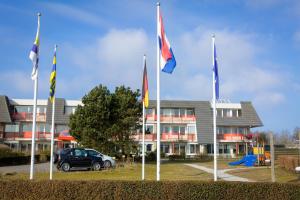 a group of flags in front of a building at Dünenglück in Buren