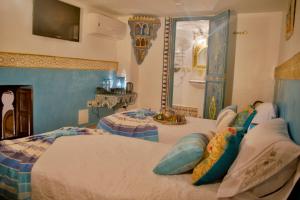 een slaapkamer met een groot bed met kussens erop bij Riad Las Mil y una Noches Tetuan in Tetouan