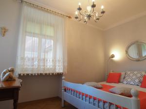 グダニスクにあるGrand-Tourist Anker Gate Apartmentsの子供用ベッドルーム(ベビーベッド、窓付)