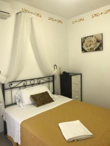 a bedroom with a bed with a brown and white blanket at Hotel Villa Lina in Loano