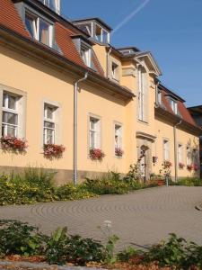 ein großes Gebäude mit Blumen davor in der Unterkunft Hotel Regenbogenhaus in Freiberg