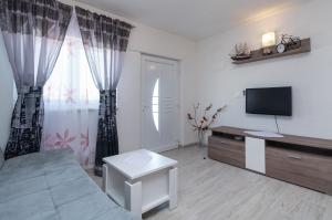 a living room with a bed and a television at Apartment PAULA in Trogir