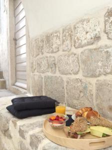 a tray of food on a table in front of a stone wall at Apartment P 35 in Dubrovnik +19 photos