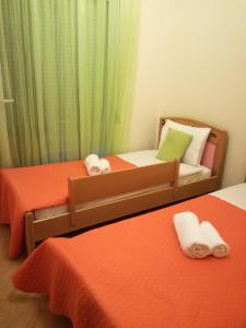 イラクリトサにあるNikolas & Anezina houseのオレンジのシーツが備わる客室で、ツインベッド2台が付いています。
