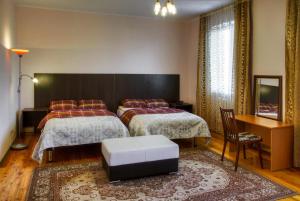 um quarto de hotel com duas camas e uma mesa em Guest House on Sadovaya em Almaty