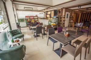 a restaurant with tables and chairs in a room at City View Residence in Si Racha