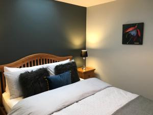 a bedroom with a bed with black and white pillows at Corrieview Barn in Fort William