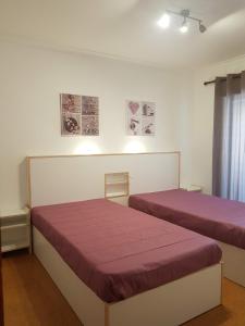 2 bedden in een kamer met paarse lakens bij AL Visconde in Ponta Delgada