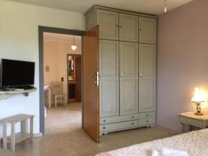 a bedroom with a large white cabinet and a television at Villa Rena in Vourvourou