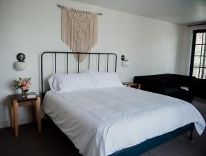 1 dormitorio con cama blanca y piano en Surf Hotel & Chateau en Buena Vista