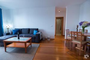 Una sala de estar con un sofá azul y una mesa. en Apartamento Estefânia, en Santa Cruz