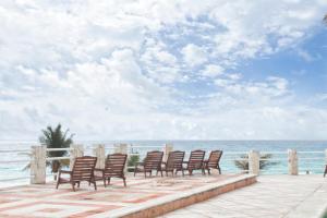 a row of chairs sitting on a patio overlooking the ocean at Rodero by Solymar Beach Front Condos in Hotel Zone in Cancún