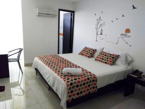 een slaapkamer met een groot bed met rode en zwarte kussens bij Hotel Cosmos Sincelejo in Sincelejo