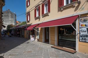a building with a red awning on a street at Apartments Antons 2 in Pula