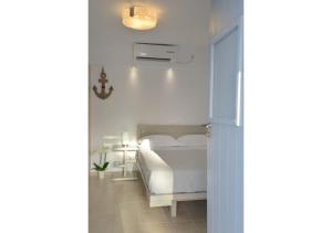 a bedroom with a white bed and a light at SeaScape Mandrakia in Mandrakia