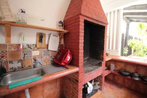a kitchen with a brick oven with a sink at Villas Roseliz in Punta Allen