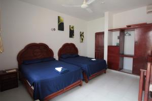 a bedroom with two beds with blue comforters at Villas Roseliz in Punta Allen