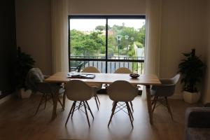 a dining room table with chairs and a large window at Holiday Cascais Apartment in Cascais