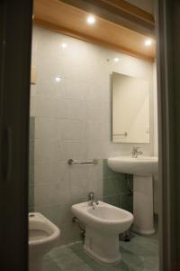 a bathroom with a sink and a toilet and a mirror at Civico24 in Scicli