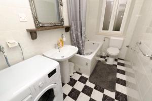 a bathroom with a washer and a sink and a washing machine at Apartments Jurica in Postira +15 photos