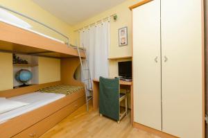 a bedroom with a bunk bed and a desk at Apartments Jurica in Postira