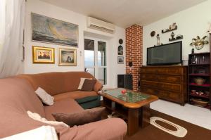 a living room with a couch and a television at Apartments Jurica in Postira