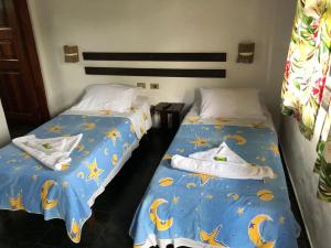 dos camas sentadas una al lado de la otra en una habitación en Pousada Conde do Mar, en Ilhabela