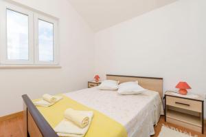 a bedroom with a bed and a window at Apartments Marinko in Splitska